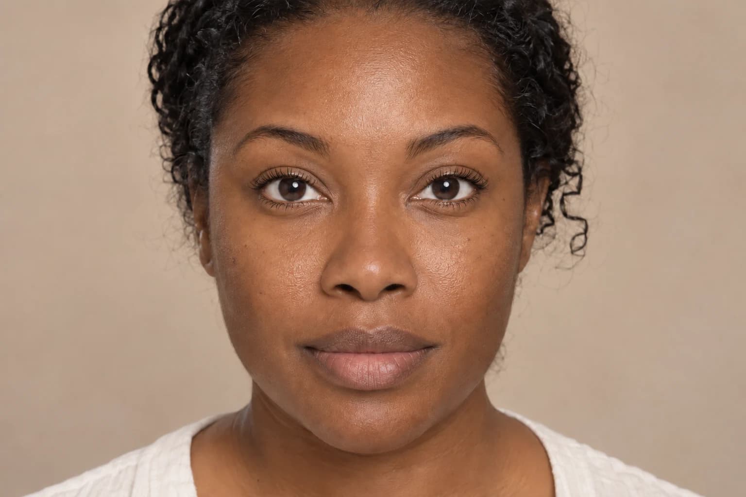 Woman with dark curly hair wearing fuller, darker mascara and fanned-out upper lashes